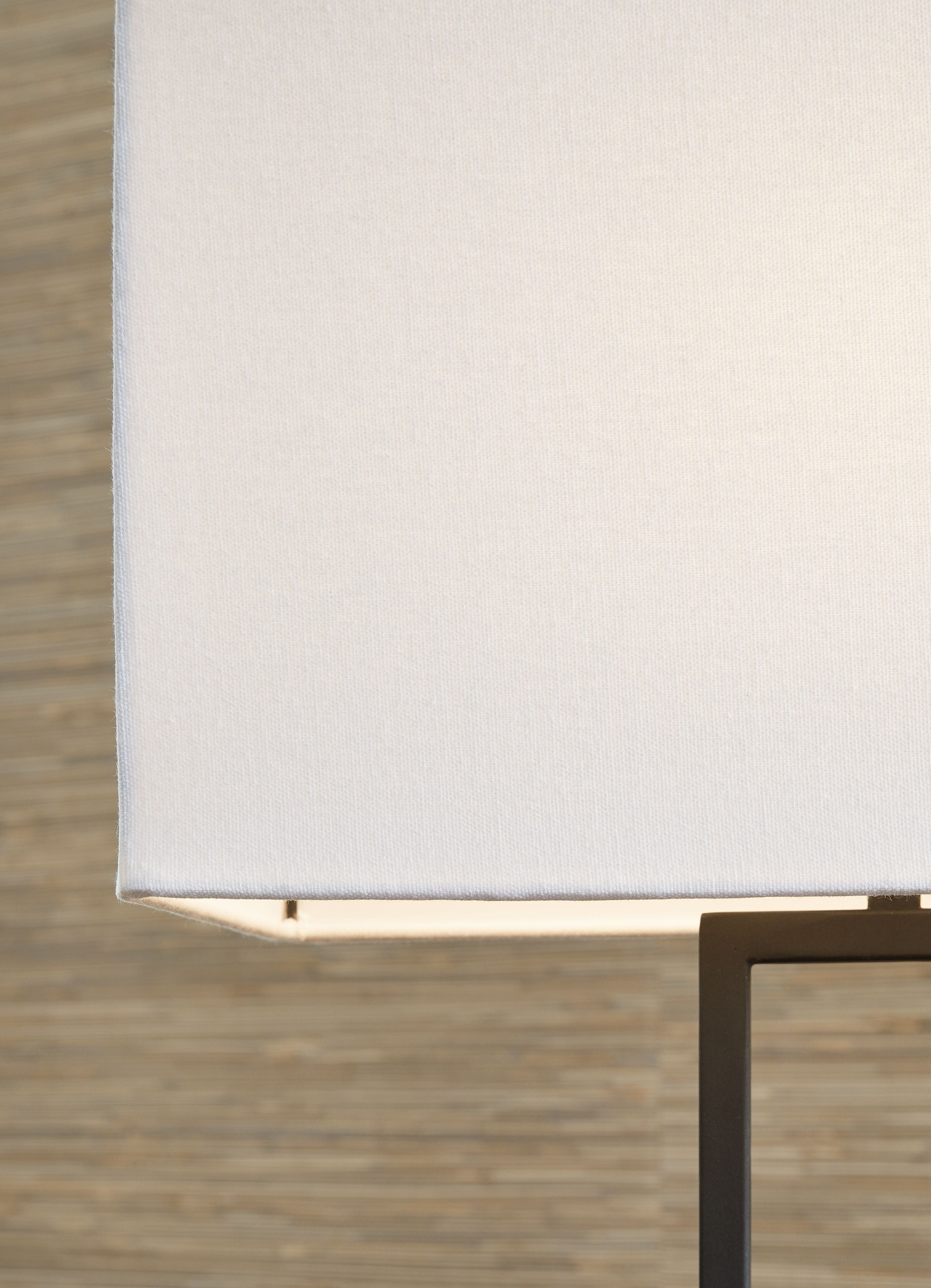 Metal table lamp with white fabric shade and black frame, partial close-up