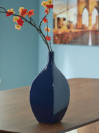 Blue ceramic vase with glossy finish and floral branch, teardrop shape