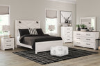 White panel bedroom set with bed, nightstands, dresser, and mirror