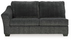 Dark gray fabric sofa sleeper with padded arms and tufted back cushions