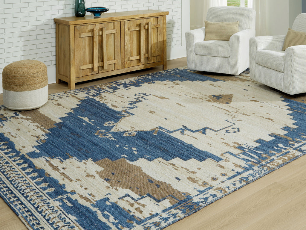 Large area rug with cream ground, blue blocks, and distressed geometric medallion border