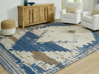 Large area rug with cream ground, blue blocks, and distressed geometric medallion border