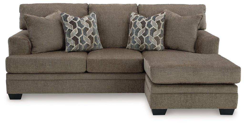 Sofa chaise in taupe fabric with two geometric patterned throw pillows