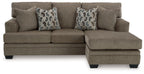 Sofa chaise in taupe fabric with two geometric patterned throw pillows