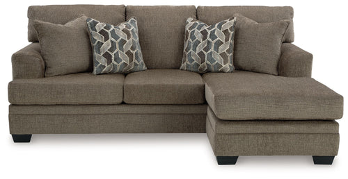 Sofa chaise in taupe fabric with two geometric patterned throw pillows