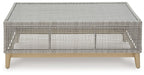 Gray rectangular cocktail table with woven top and open base frame on legs