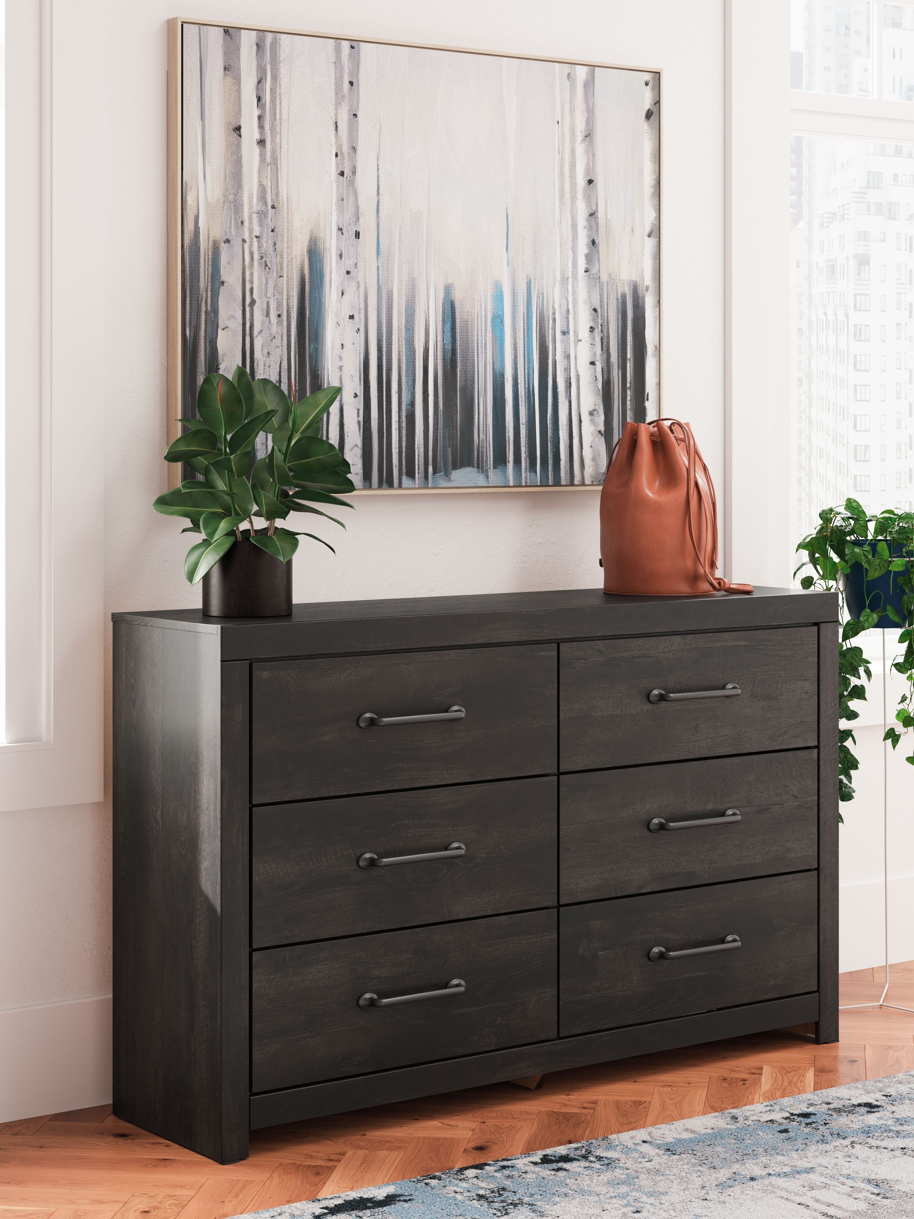 Dark gray six-drawer dresser with metal bar handles and wide top surface