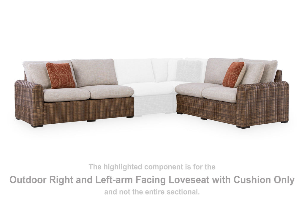 Outdoor corner loveseat set with beige cushions, brown wicker frame, rust throw pillows