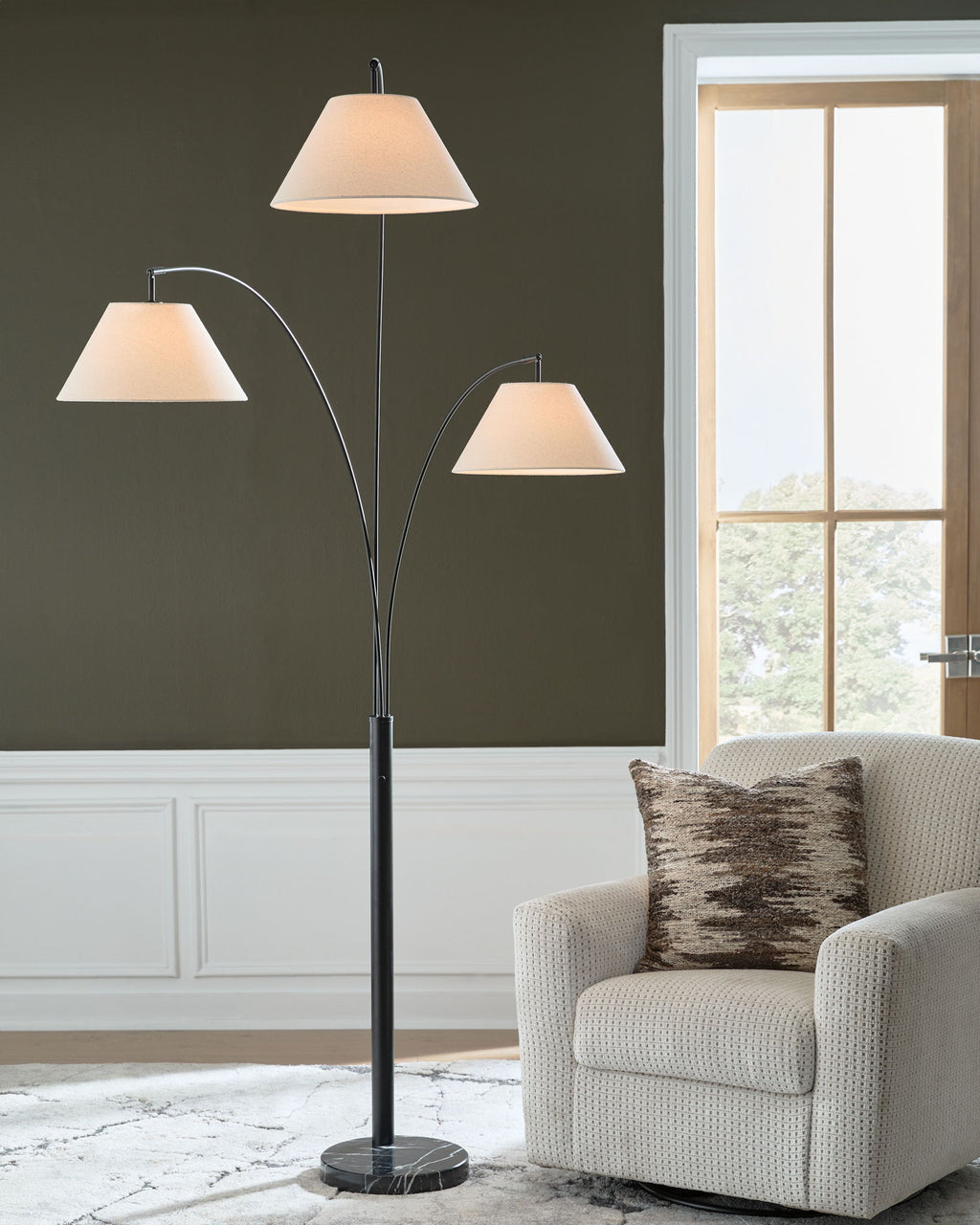 Black metal arc floor lamp with three white fabric shades and round base