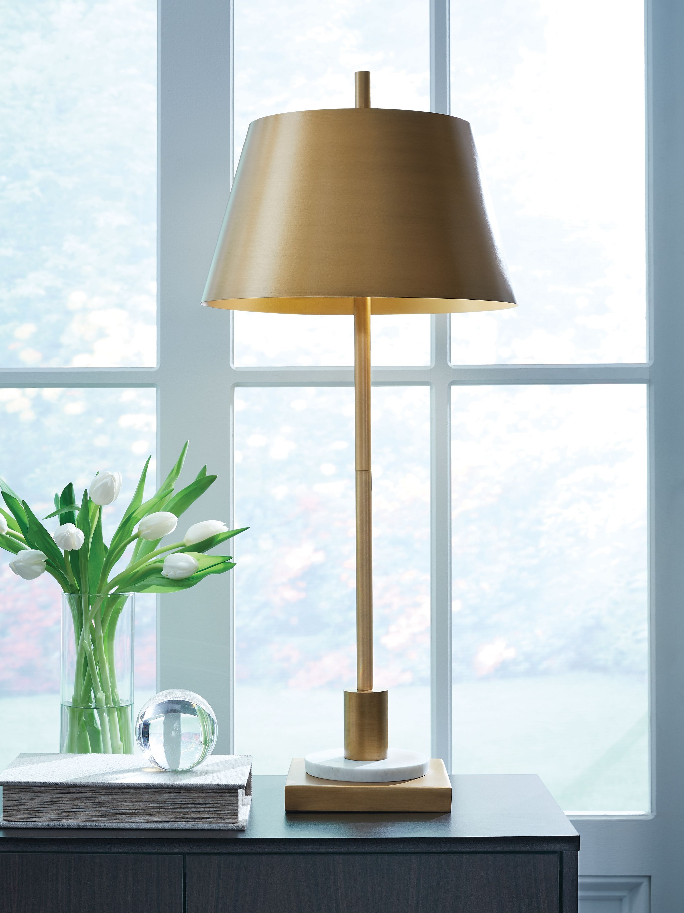 Gold metal floor-style table lamp with wide shade, cylindrical stem, and rounded base
