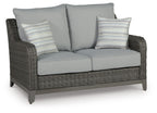 Gray wicker loveseat with two seat cushions, two back cushions, and striped pillows