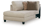 Latte corner chaise with beige upholstery and two accent pillows, dark legs