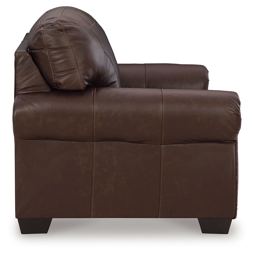 Dark brown loveseat side view with rolled arm and tufted back cushion