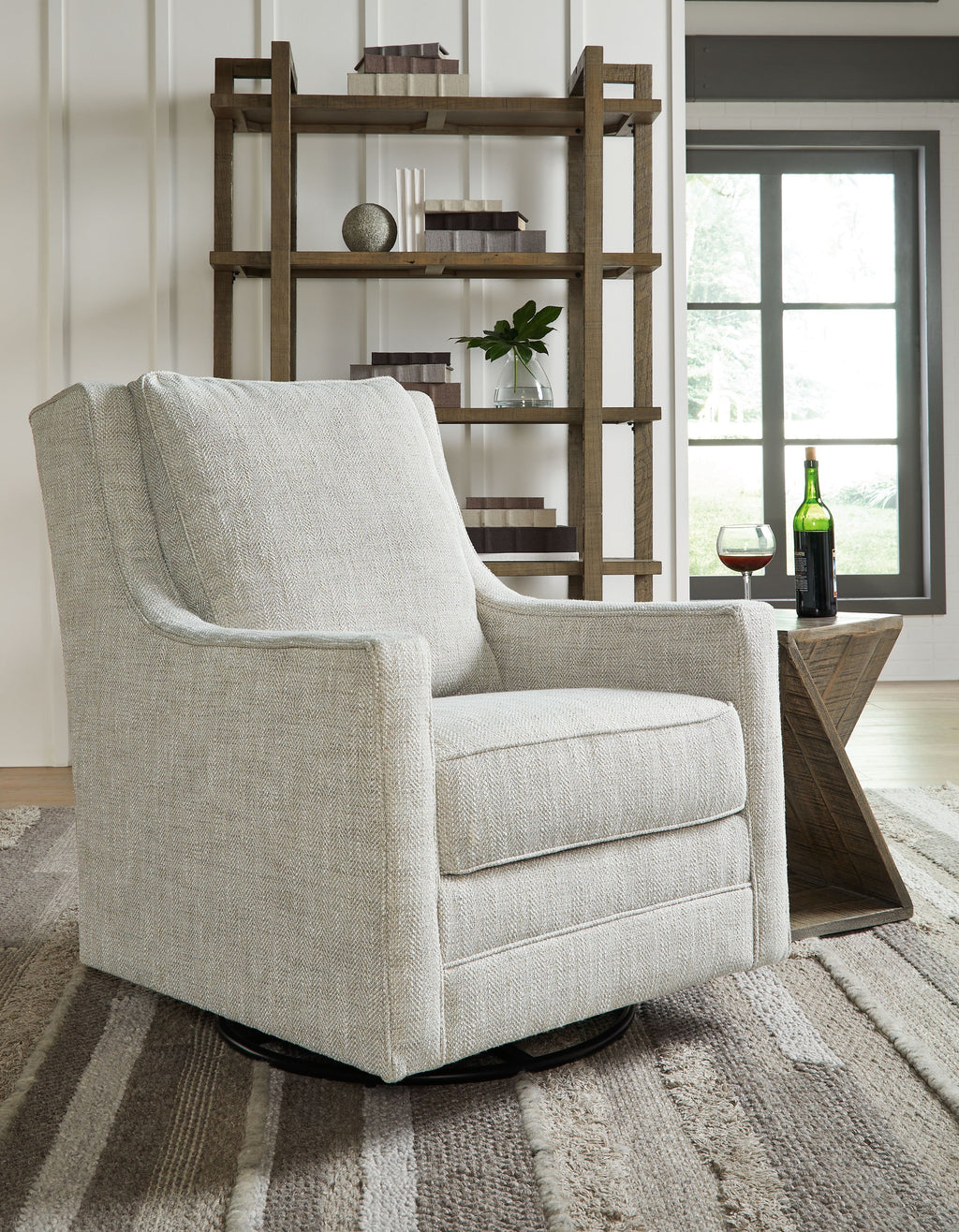 Light gray swivel accent chair with wide arms and thick seat cushion, black base