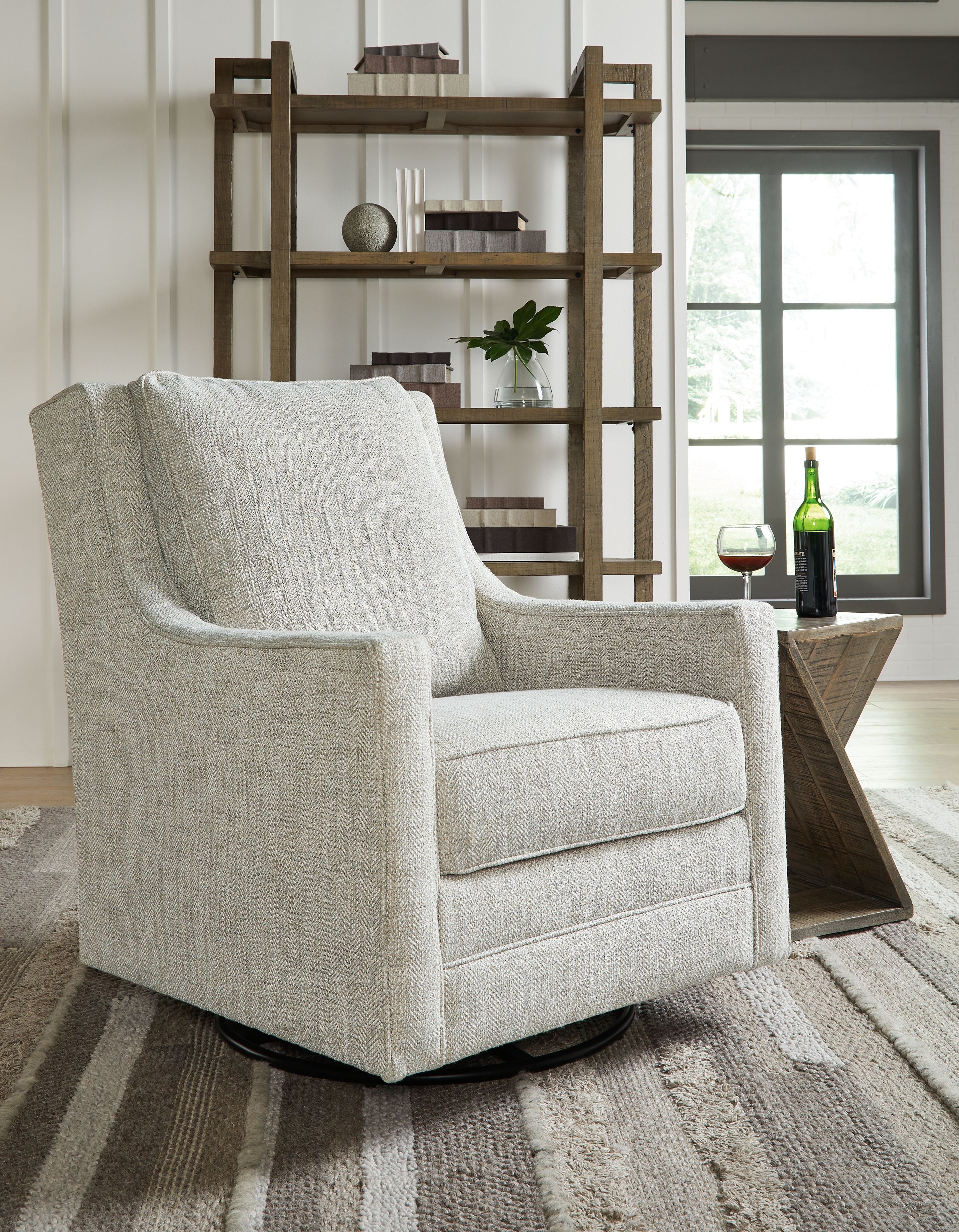 Light gray swivel accent chair with wide arms and thick seat cushion, black base