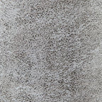 Textured speckled ceramic surface, light gray with darker dots and mottled finish.