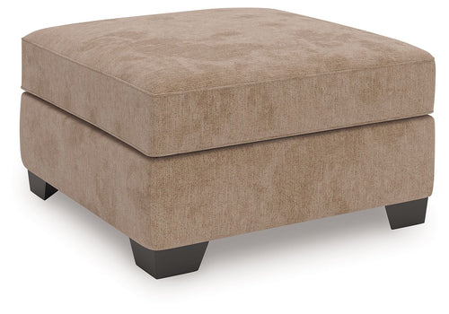 Light brown upholstered ottoman with thick padded top and block legs