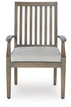 Wooden arm chair with tall slatted back and light beige seat cushion, square legs.