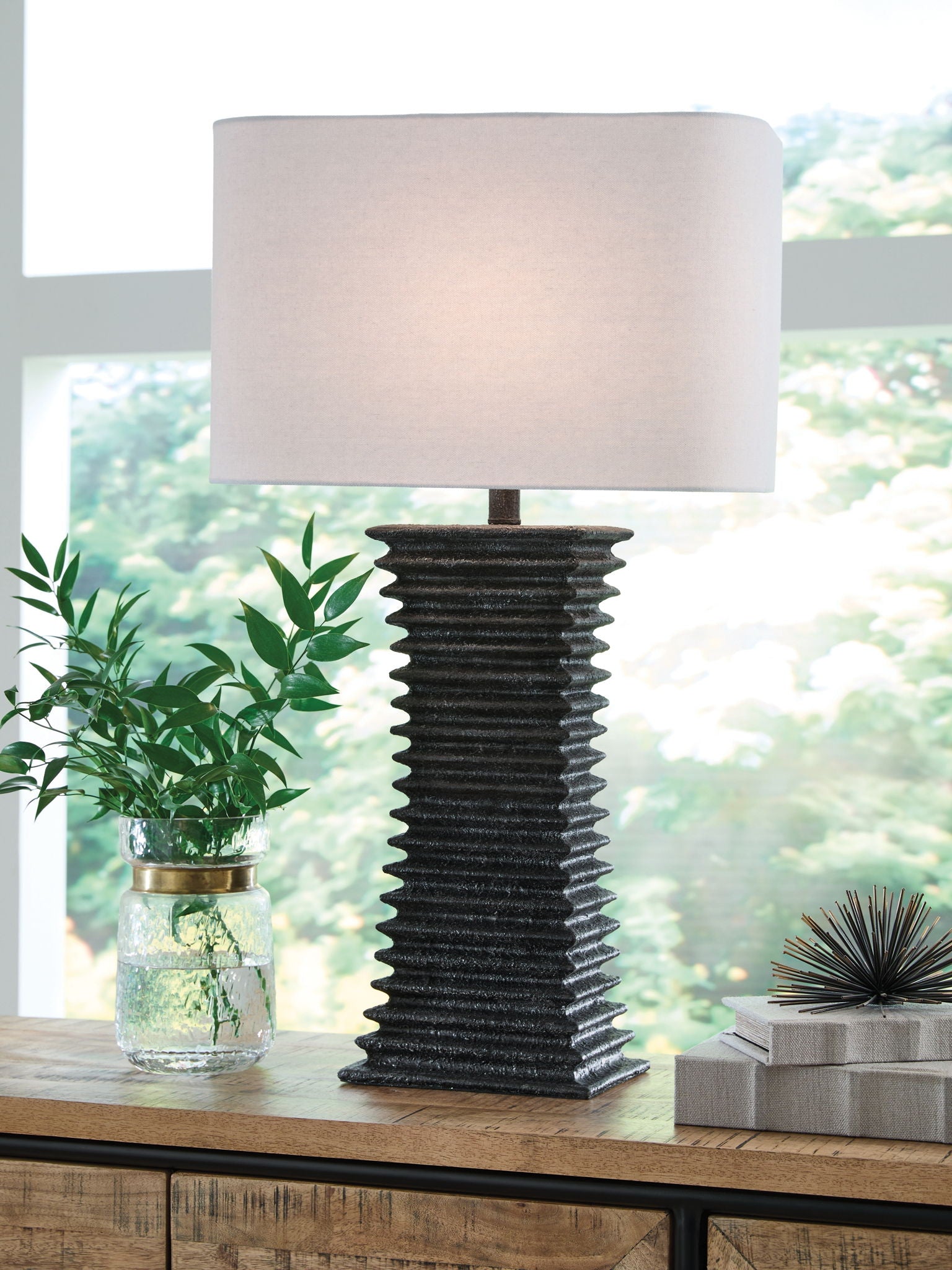 Poly table lamp with white shade and dark ribbed base on tabletop