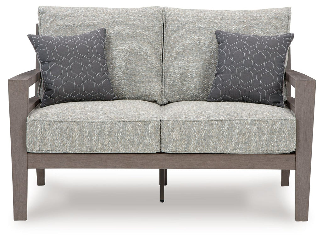 Gray loveseat with two patterned throw pillows, centered back seam, and padded seat cushions