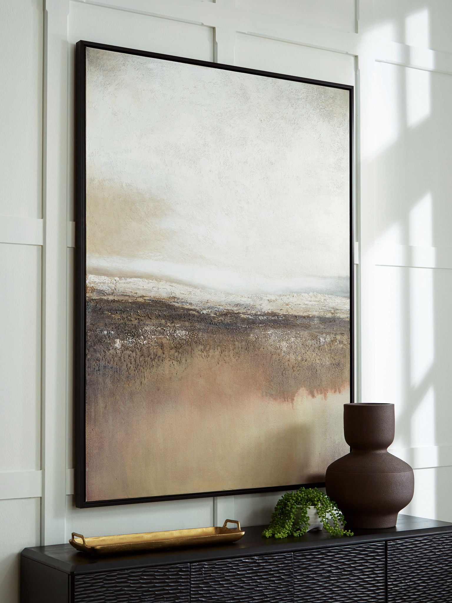 Abstract wall art in a black frame with gray and beige horizon layers
