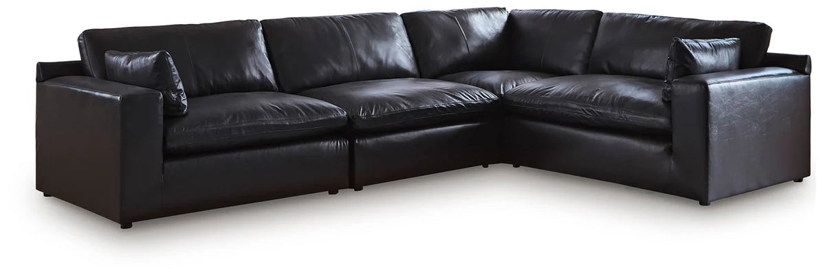Black leather-look L-shaped sectional sofa with multiple seat sections and back cushions