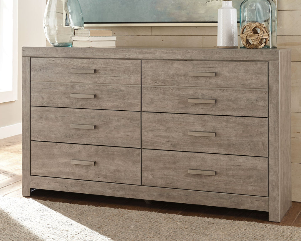 Gray wood dresser with six drawers and metal bar pull handles, front view