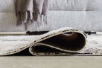 Black and gray area rug with bound edge and visible backing