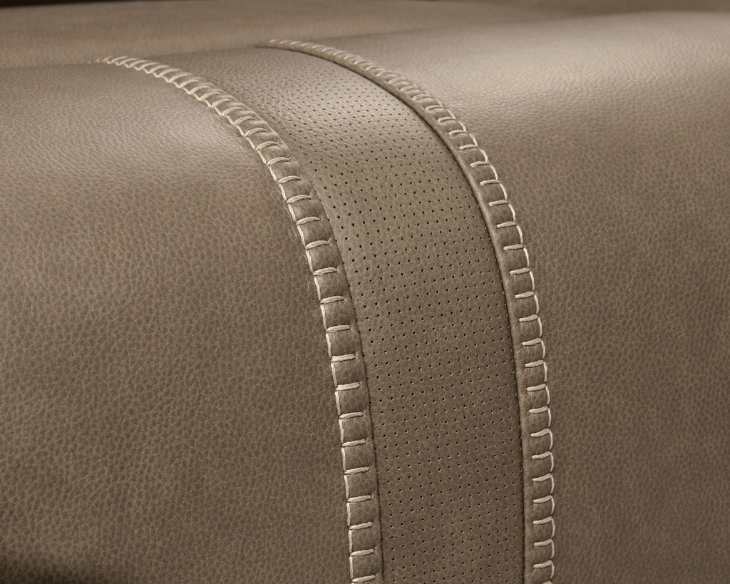 Taupe-brown upholstery with dotted texture paneling and stitched edge seams