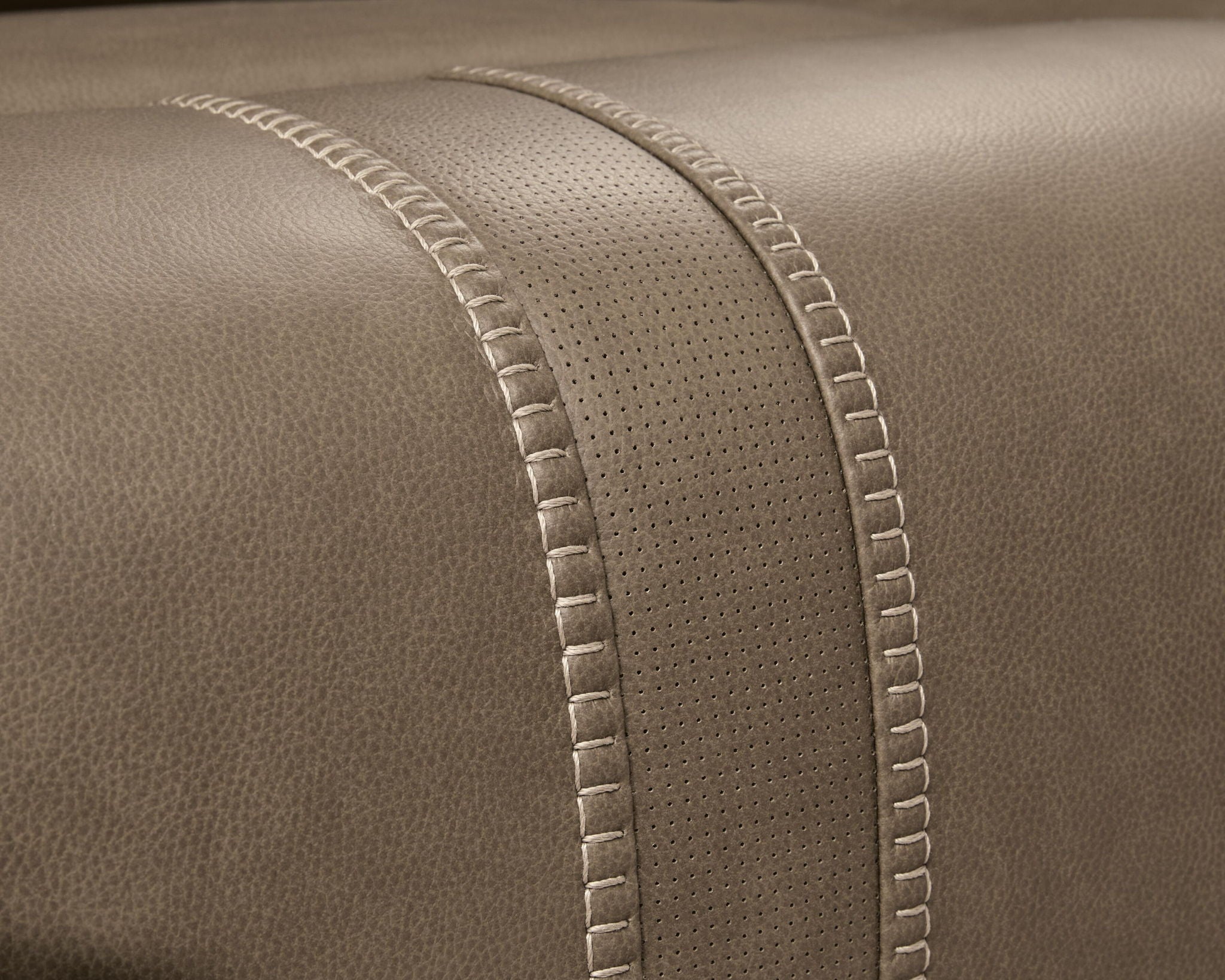 Taupe-brown upholstery with dotted texture paneling and stitched edge seams