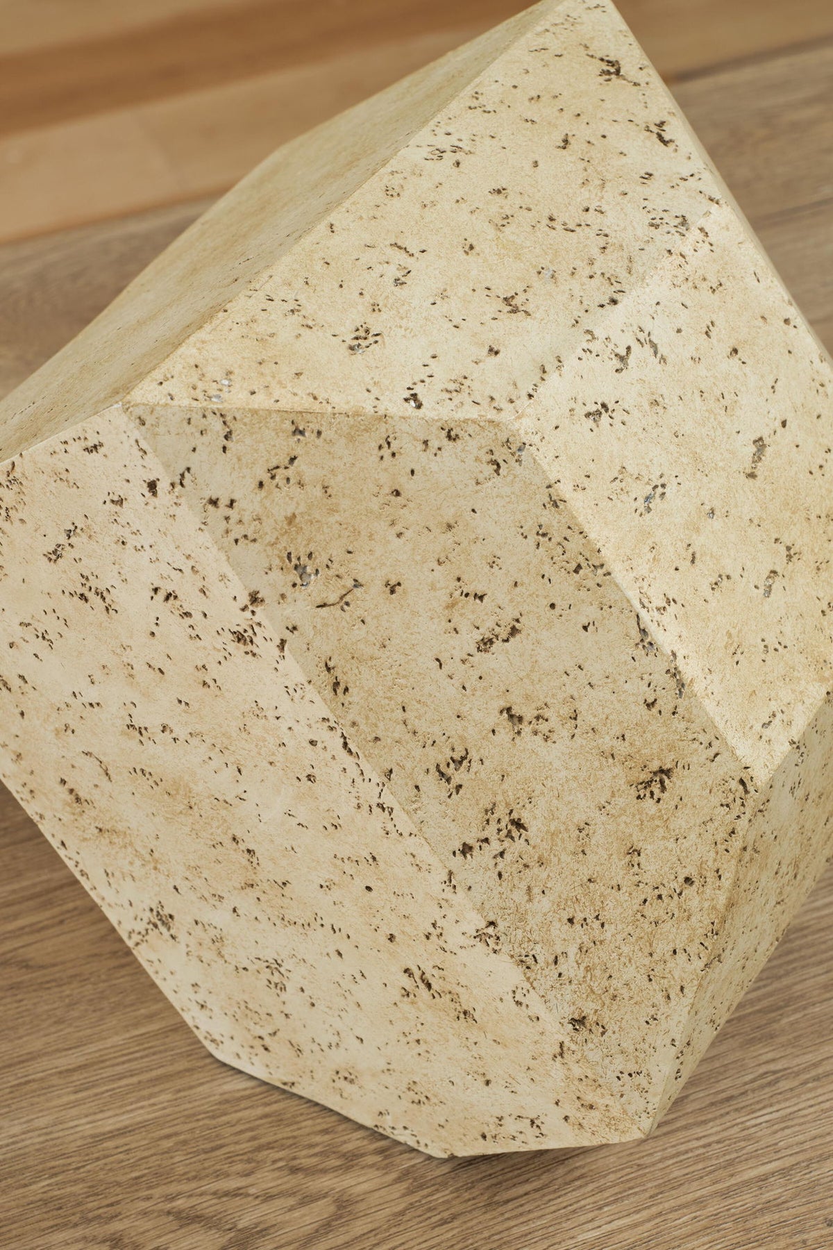 Beige speckled angular sculpture, close-up of faceted sides