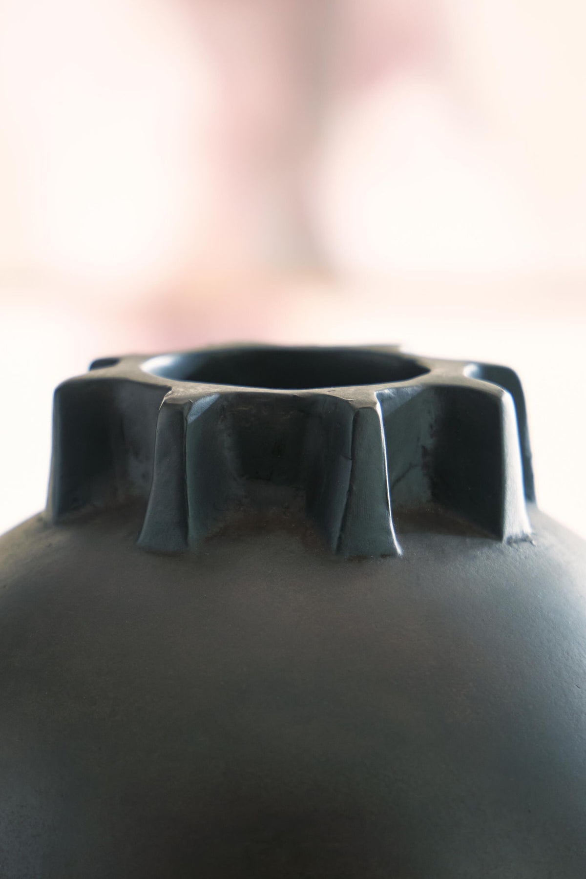 Antique black vase with fluted rim and ribbed collar at top opening