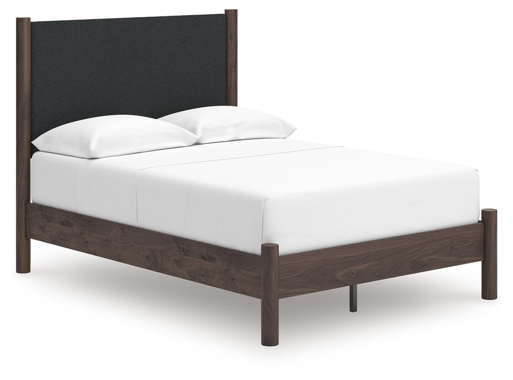 Dark brown upholstered panel platform bed with white mattress and two pillows