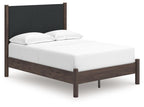 Dark brown upholstered panel platform bed with white mattress and two pillows