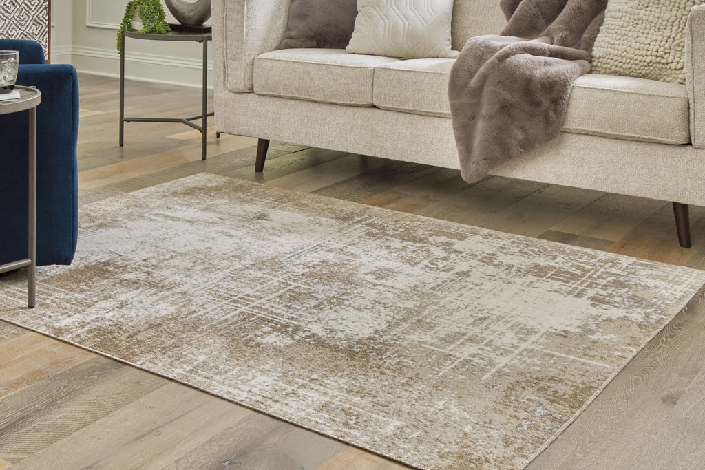 Light brown distressed area rug in living room beneath sofa and chair