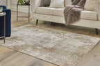 Light brown distressed area rug in living room beneath sofa and chair