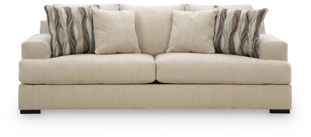 Beige upholstered sofa with two seat cushions and striped back pillows