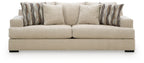 Beige upholstered sofa with two seat cushions and striped back pillows