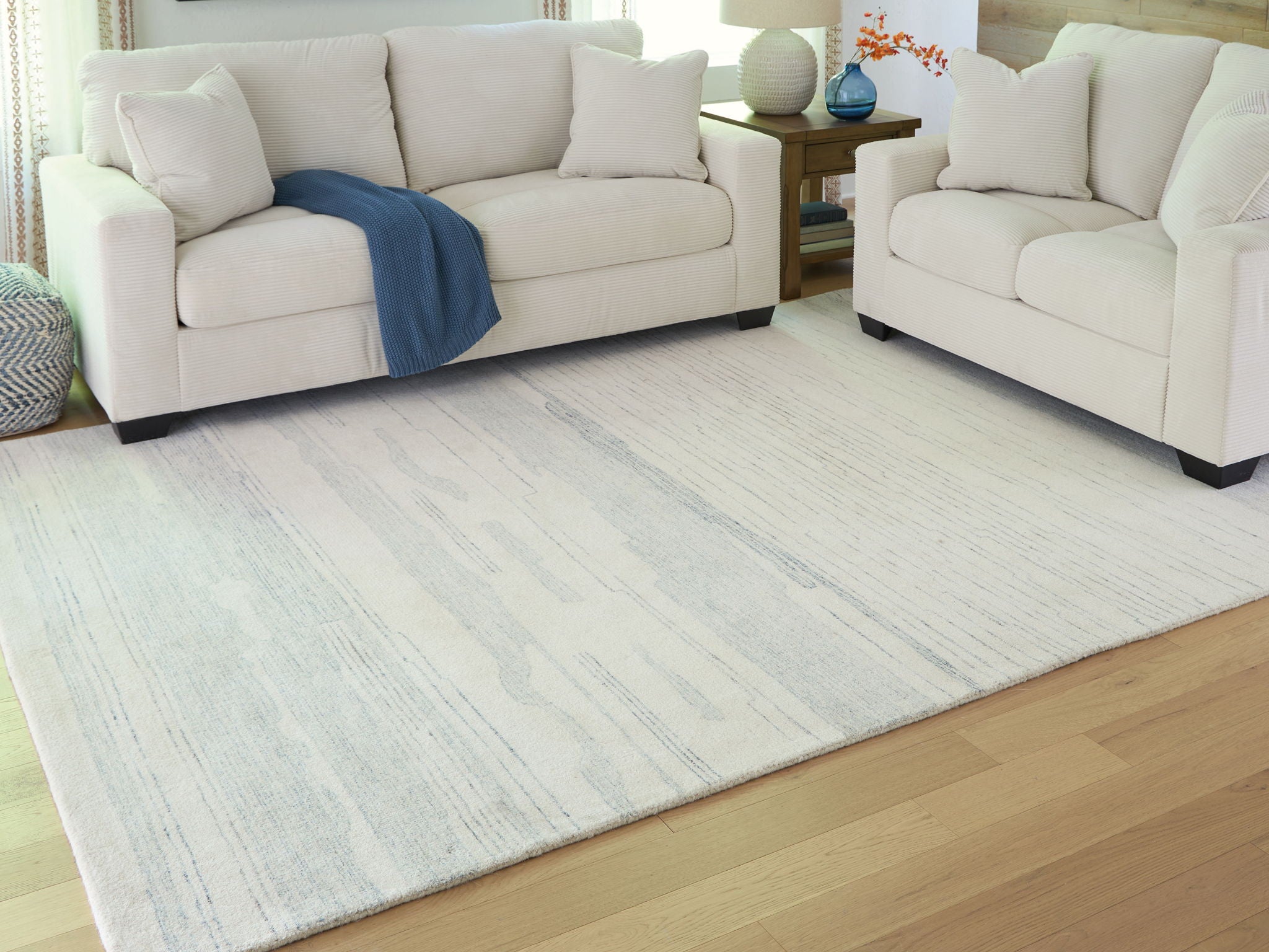 Light blue and white abstract rug with horizontal bands and subtle texture