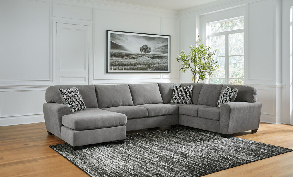 Gray sectional sofa with corner chaise and multiple patterned accent pillows
