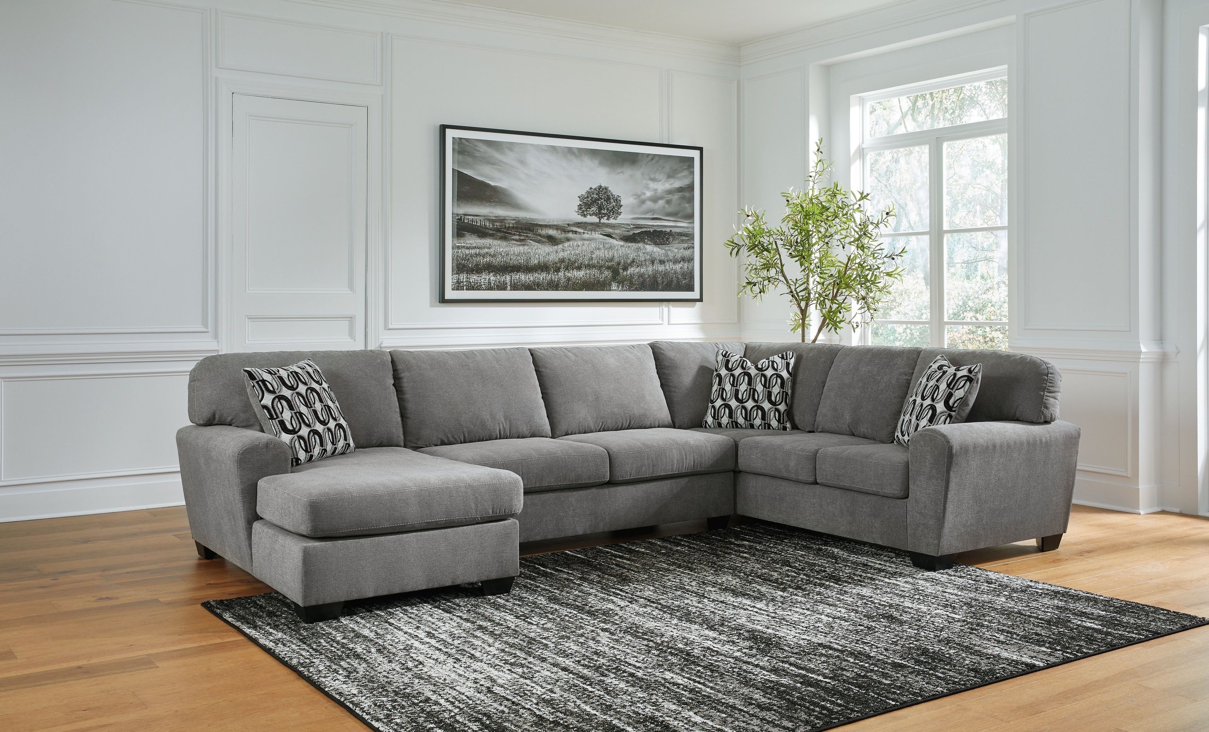 Gray sectional sofa with corner chaise and multiple patterned accent pillows