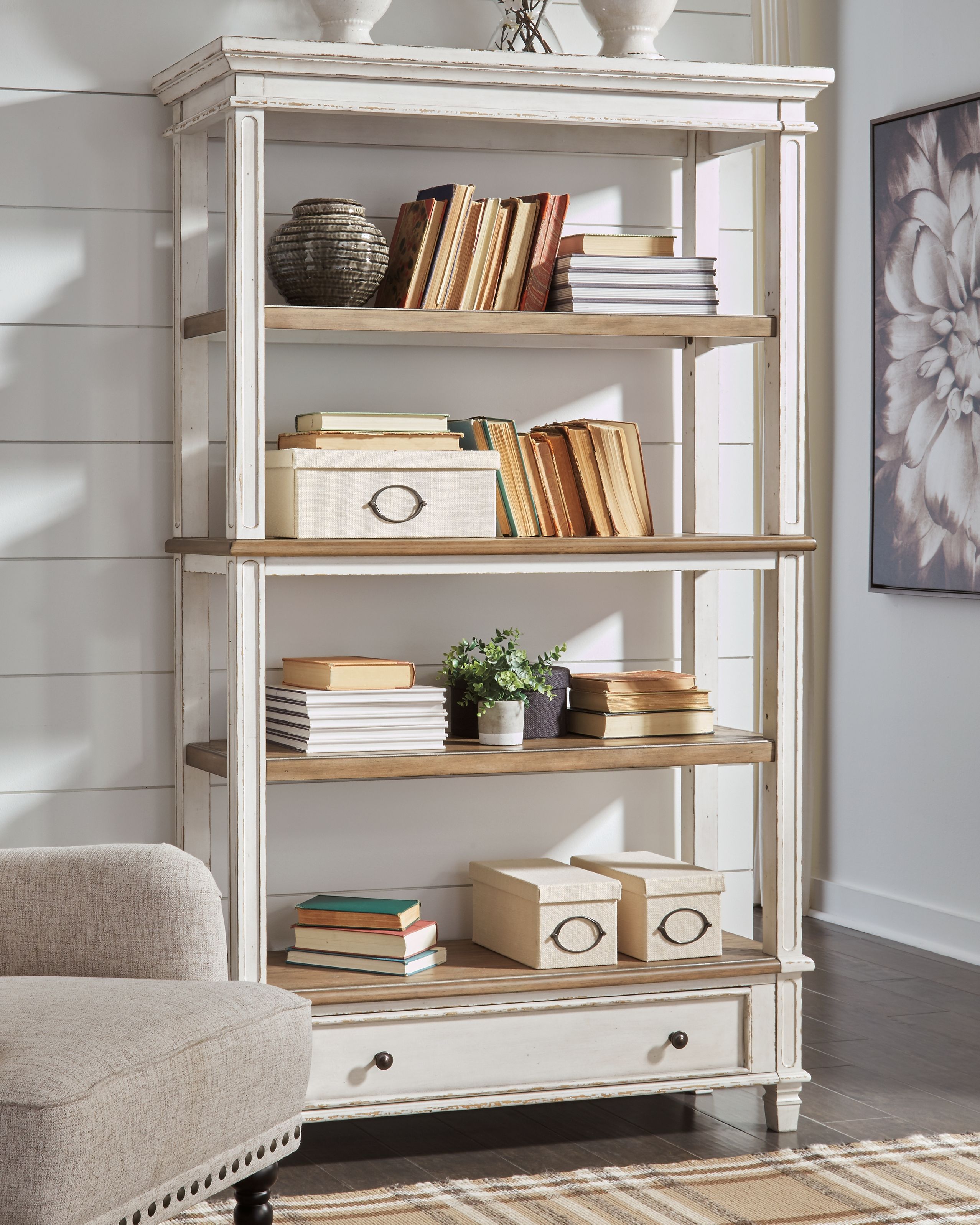 White wood bookcase with open shelves, brown panels, and two lower drawers.