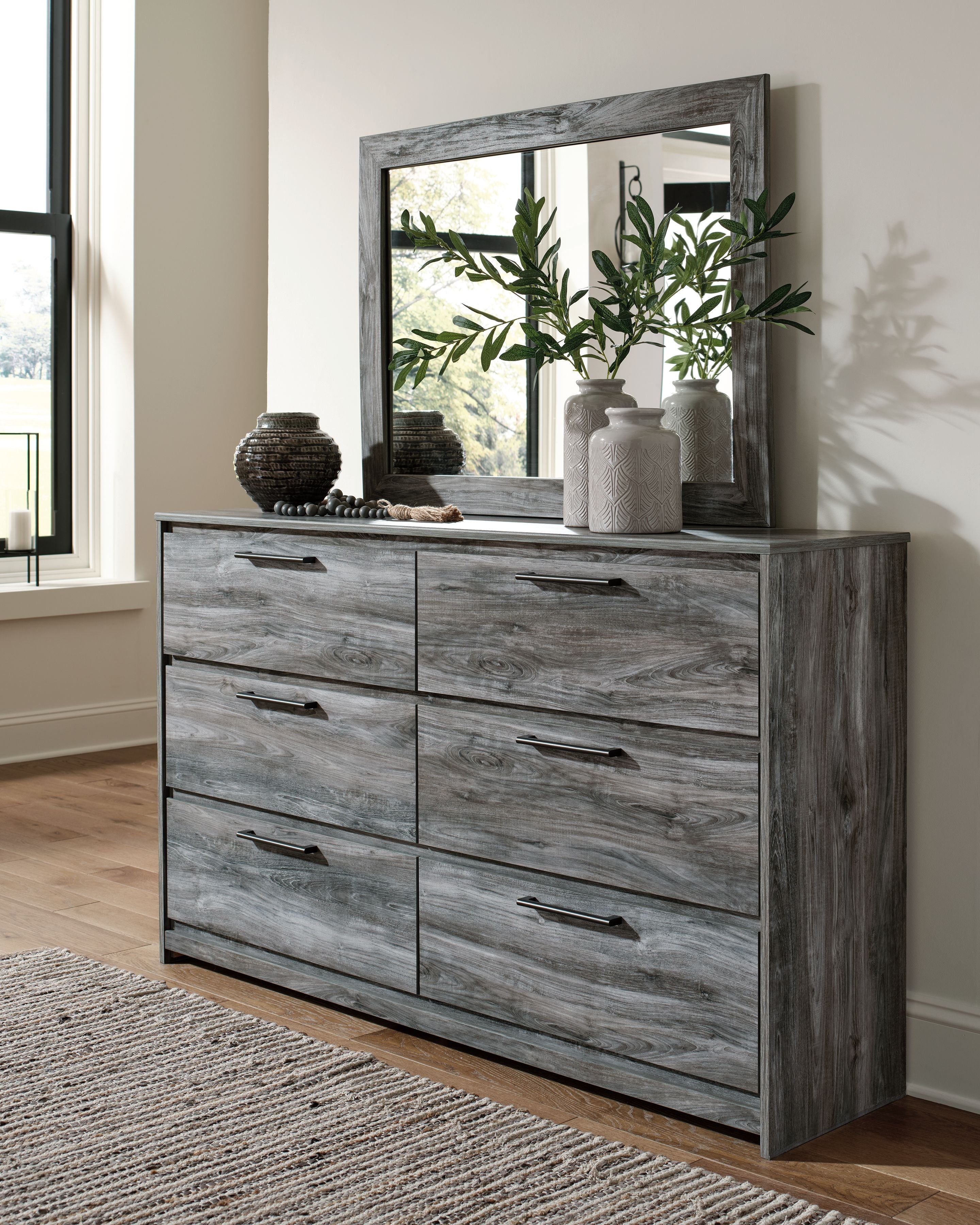 Dark gray dresser with tall rectangular mirror and six drawers, side view