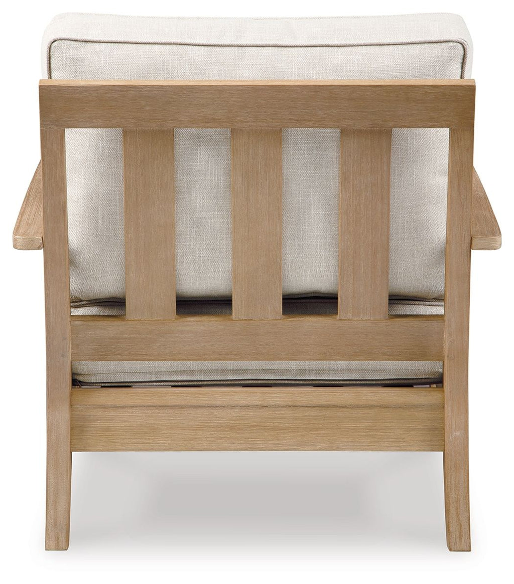 Beige lounge chair with cushion, vertical slat back and upholstered seat, light wood.