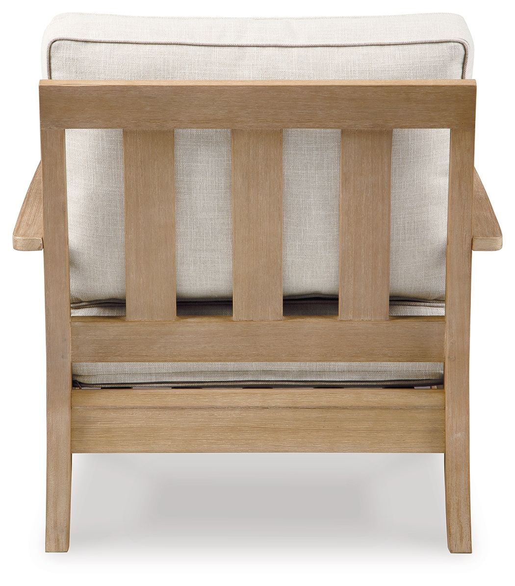 Beige lounge chair with cushion, vertical slat back and upholstered seat, light wood.