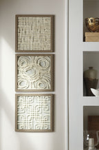 Three framed abstract wall art panels stacked on wall in cream tones with taupe frames.