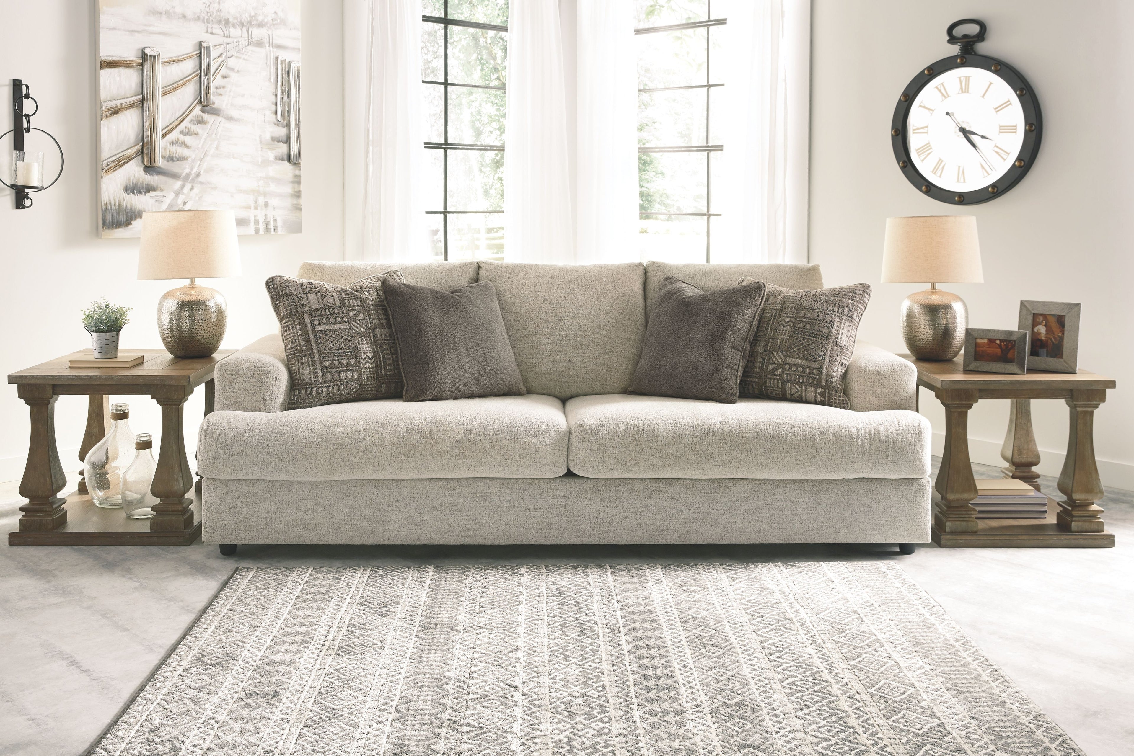 Beige fabric loveseat with three patterned throw pillows