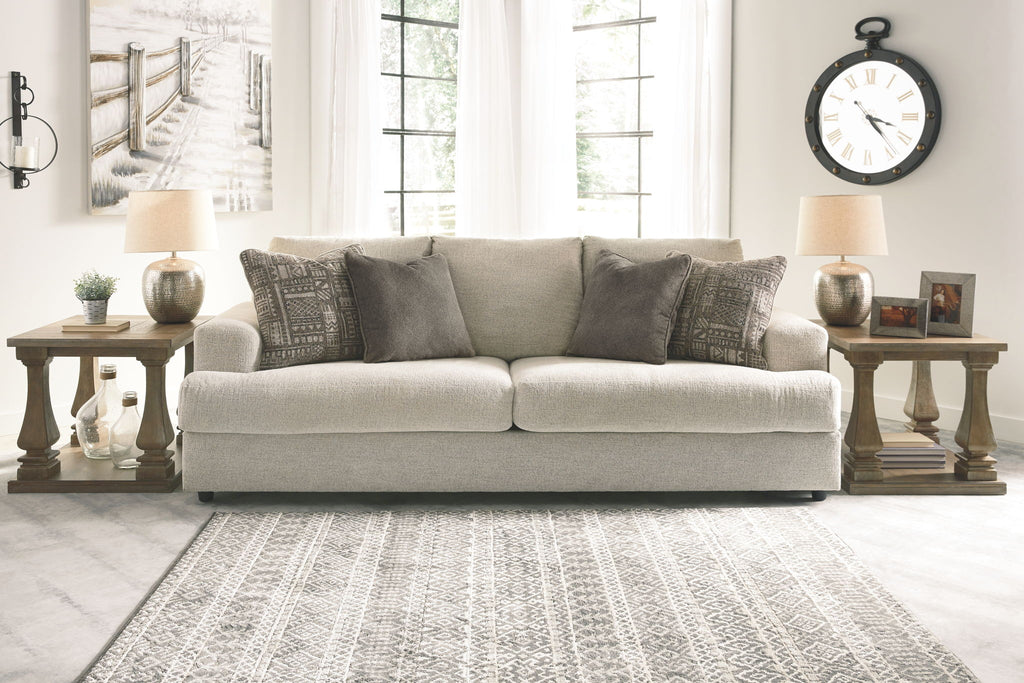 Stone upholstered sofa with three throw pillows