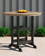 Round bar table with driftwood round top, black legs, and lower open shelf
