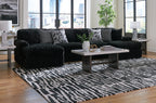 Black corduroy sectional sofa with chaise corner and geometric throw pillows